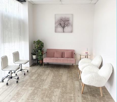 The lounge with a blush pink sofa and white chairs