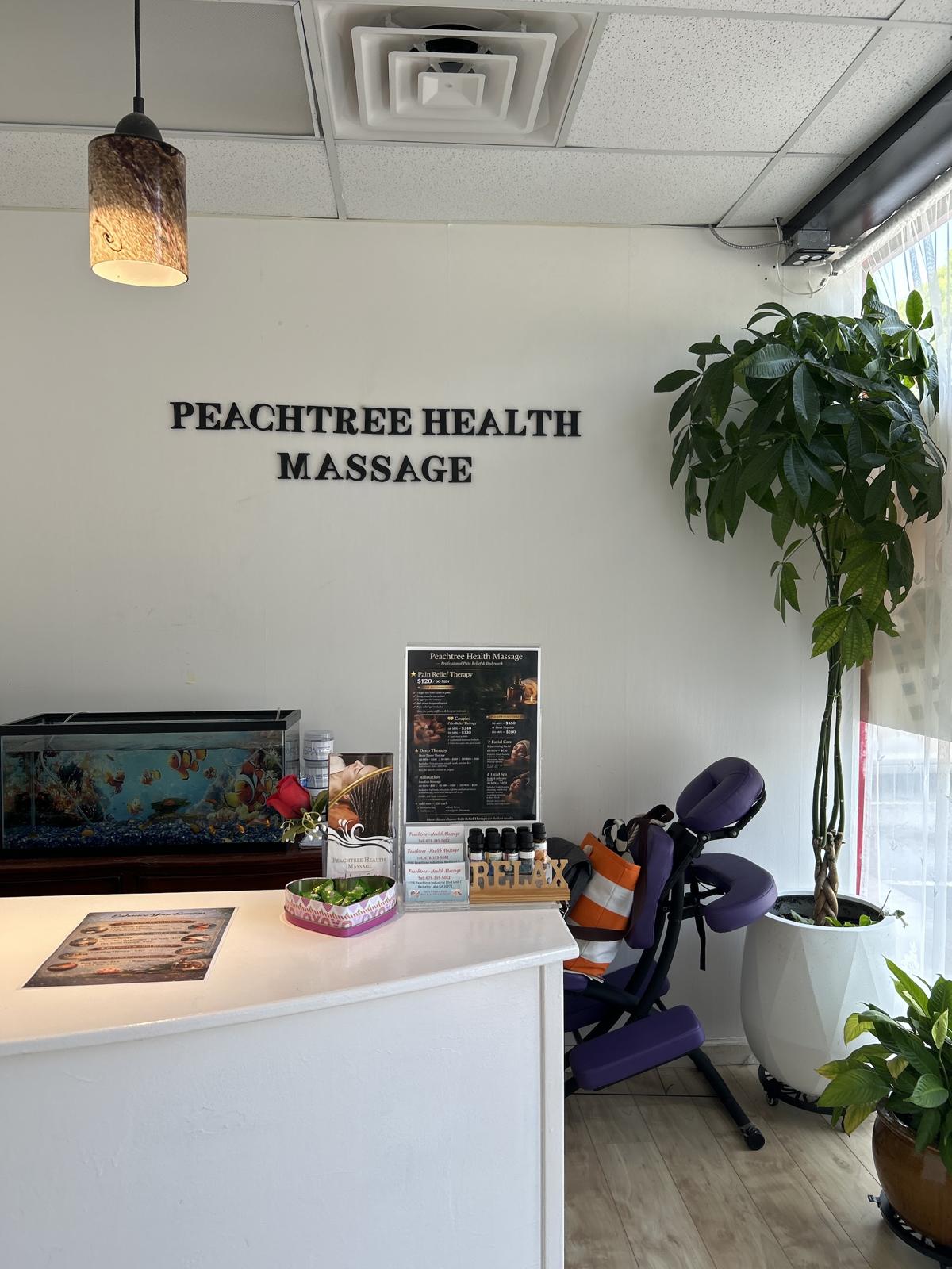Our reception desk with the Peachtree Health Massage lettering and a massage chair